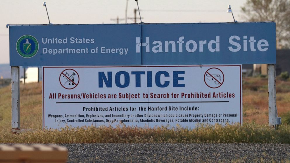 FILE - In this May 9, 2017, file photo, signs are posted at an entrance to the Hanford Nuclear Reservation in Richland, Wash.The state of Washington believes the federal government is unlikely to meet legal deadlines for emptying underground tanks ho