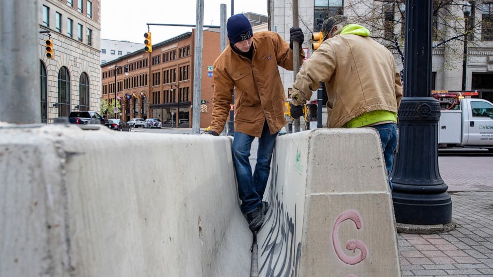 Cole Bond, left, and Mike Jack, from Fence Consultants of West Michigan, put up barricades in downtown Grand Rapids, Mich., Tuesday, April 20, 2021, as a jury deliberates fate of Derek Chauvin in death of George Floyd. Grand Rapids had some of Michig