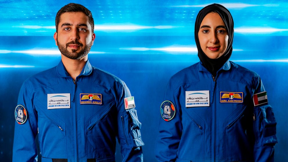 In this undated handout photograph from the United Arab Emirates' state-run WAM news agency, newly named Emirati astronauts Mohammed al-Mulla, left, and Noura al-Matroushi, right, pose for a photo. The United Arab Emirates named the next two astronau