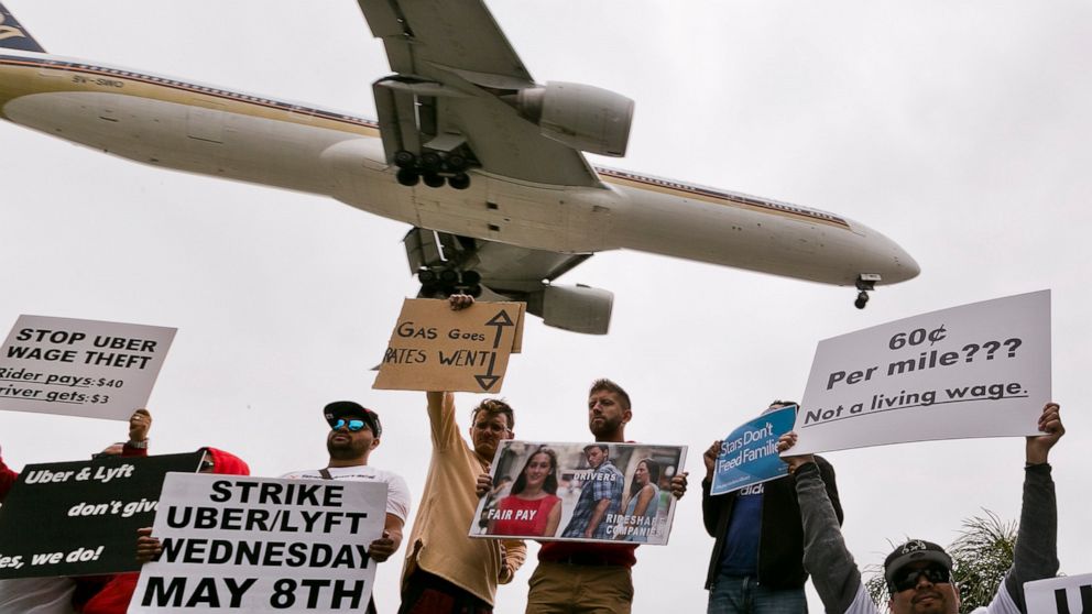 FILE - In this Wednesday, May, 8, 2019 file photo, drivers for ride-hailing companies Uber and Lyft hold a rally at a park near Los Angeles International Airport. Some drivers for ride-hailing giants Uber and Lyft turned off their apps to protest wha