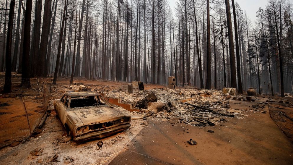 A vehicle and property were destroyed by the Caldor Fire sit in Grizzly Flats, Calif., on Tuesday, Aug. 17, 2021. (AP Photo/Ethan Swope)