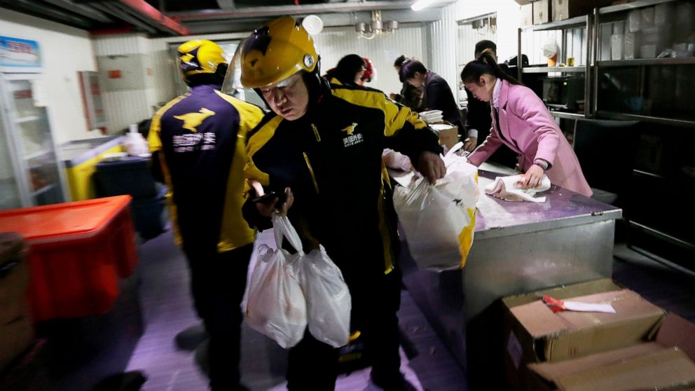 FILE - In this March 1, 2016, file photo, food delivery workers from Meituan, an E-commerce company, prepare to deliver orders placed online from a center in Beijing. Chinese food delivery giant Meituan said this week it raised nearly $10 billion in 