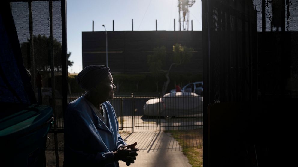 FILE - Q.C. Kelker, 83, stands at her home across the street from the Jefferson oil drill site Thursday, June 24, 2021, in Los Angeles. Los Angeles doesn't have pumpjacks dotting a desolate desert like western Texas. Its oil and gas operations are ne