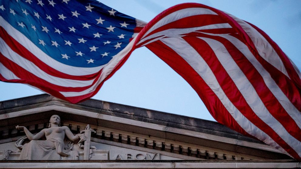 FILE - In this March 22, 2019 file photo, an American flag flies outside the Department of Justice in Washington. The Justice Department has assembled a task force to confront ransomware after what officials say was the most costly year on record for