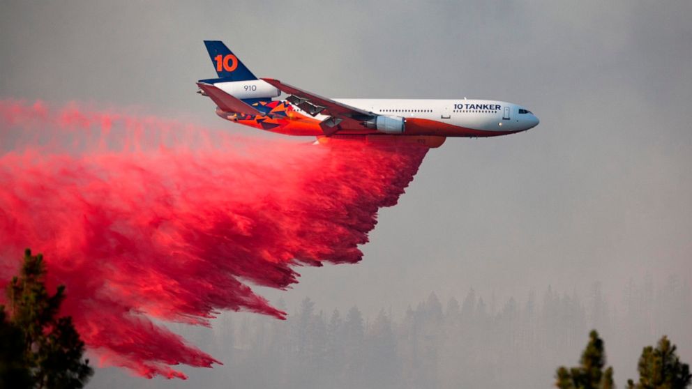 In this photo provided by the Bootleg Fire Incident Command, a DC-10 tanker drops retardant over the Bootleg Fire in southern Oregon, Thursday, July 15, 2021. Meteorologists predicted critically dangerous fire weather through at least Monday with lig