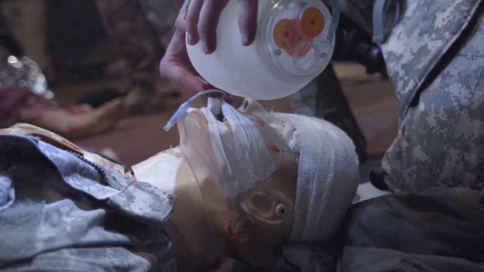 A student performs intubation on a mannequin, which is equipped with lungs that inflate.