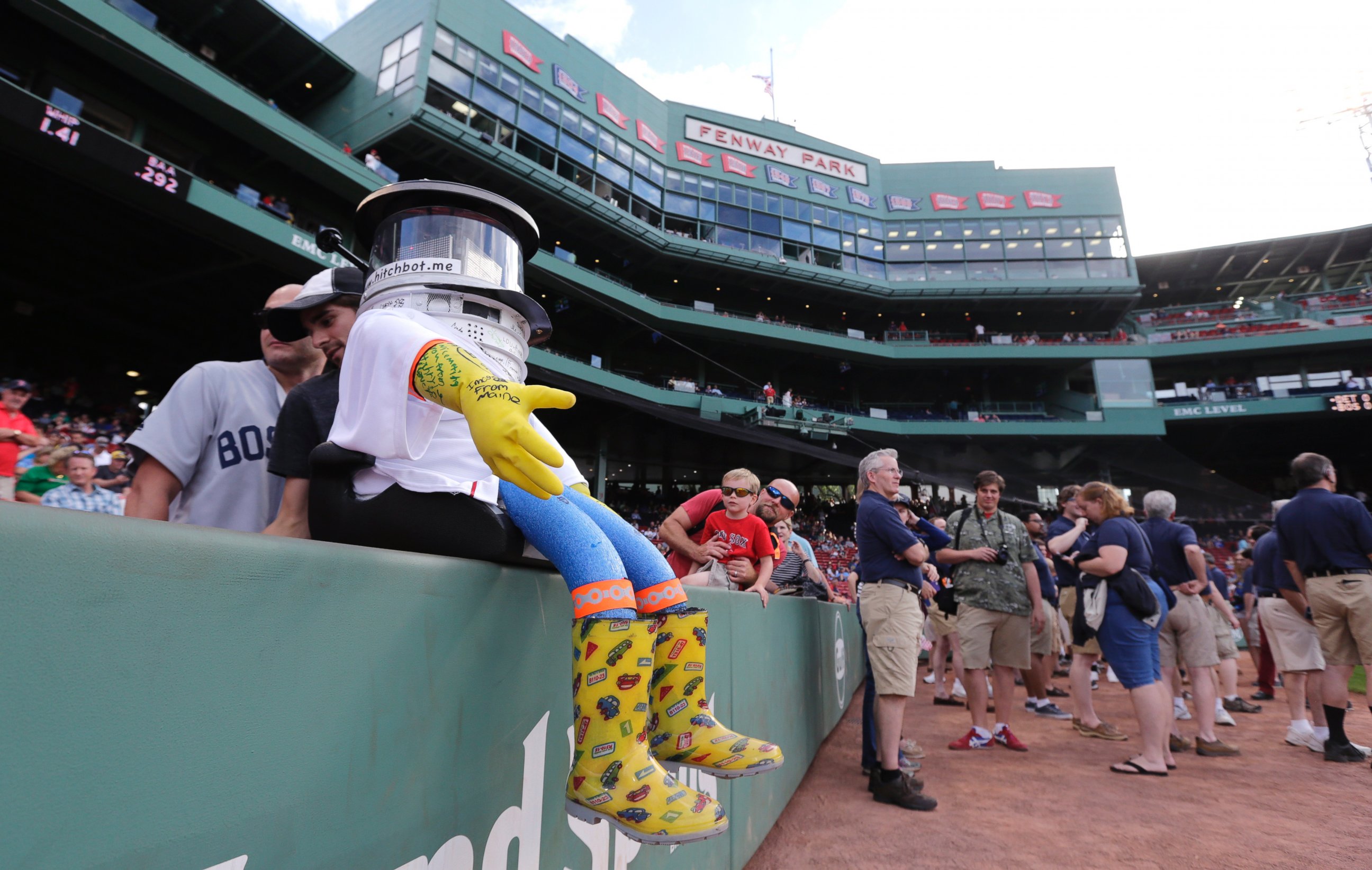 PHOTO: As pre-game activity begins, HitchBOT rests on the wall along the first base line before a baseball game at Fenway Park between the Boston Red Sox and Detroit Tigers in Boston, Friday, July 24, 2015.