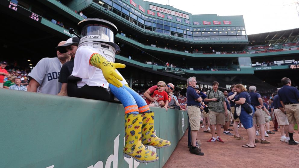 PHOTO: As pre-game activity begins, HitchBOT rests on the wall along the first base line before a baseball game at Fenway Park between the Boston Red Sox and Detroit Tigers in Boston, Friday, July 24, 2015.