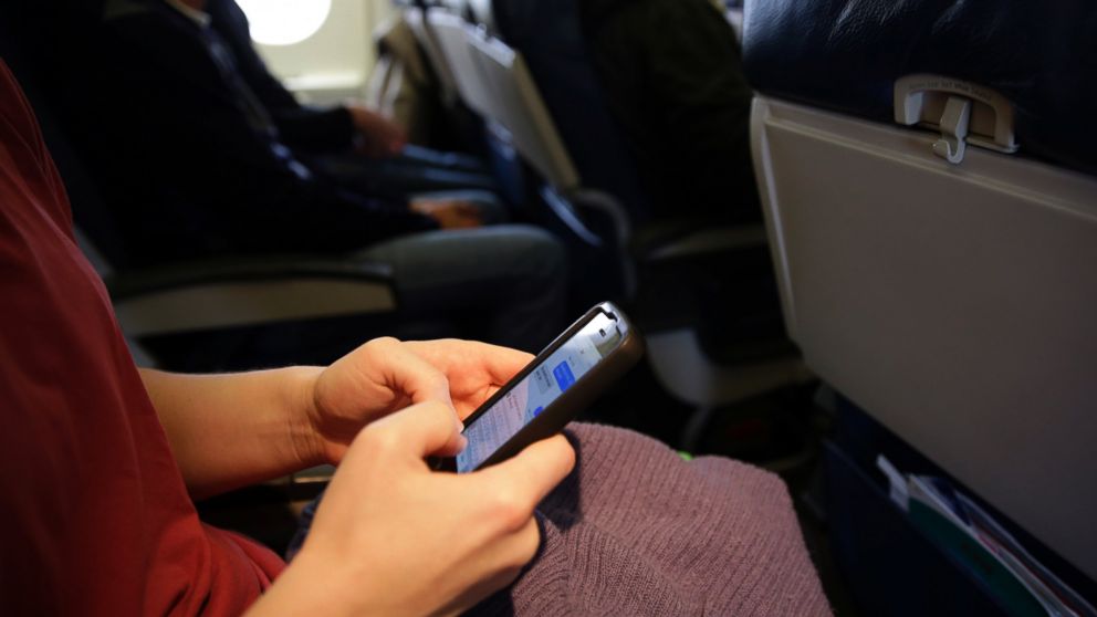 PHOTO: In this Oct. 31, 201 file photo, a passenger checks her cell phone after boarding a flight. 