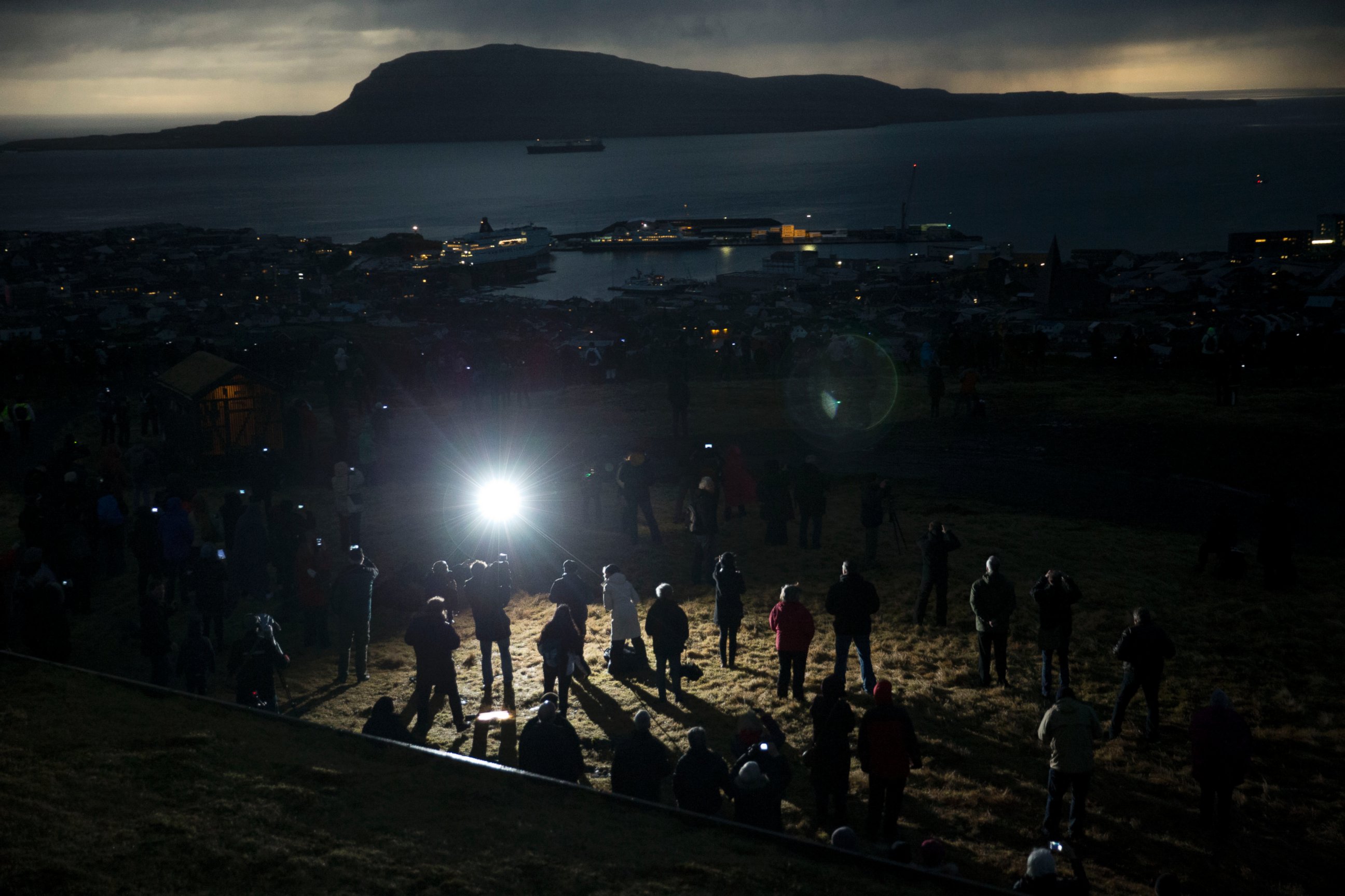 PHOTO: People watch in darkness during the totality of a solar eclipse on as seen from a hill beside a hotel on the edge of the city overlooking Torshavn, the capital city of the Faeroe Islands, March 20, 2015.