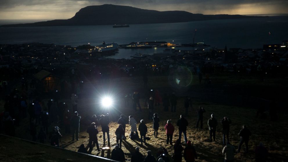 PHOTO: People watch in darkness during the totality of a solar eclipse on as seen from a hill beside a hotel on the edge of the city overlooking Torshavn, the capital city of the Faeroe Islands, March 20, 2015.
