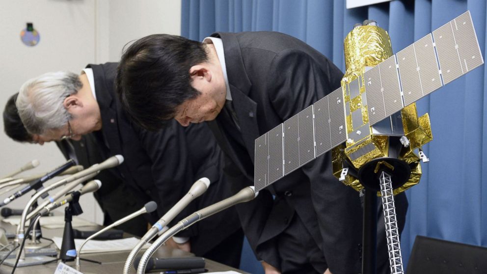 Officials of the Japan Aerospace Exploration Agency bow beside the model of an X-ray astronomy satellite called "Hitomi" in the agency in Tokyo, Japan, April 28, 2016.
