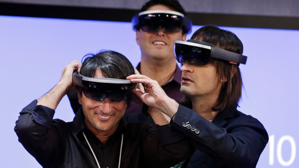 Microsoft's Joe Belfiore smiles as he tries on a "Hololens" device following an event demonstrating new features of Windows 10 at the company's headquarters on Jan. 21, 2015, in Redmond, Wash.