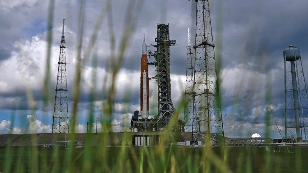 PHOTO : La fusée Artemis 1 est encadrée de hautes herbes alors qu'elle se tient prête sur la rampe de lancement 39-B au Kennedy Space Center, le 26 août 2022, à Cap Canaveral, en Floride.
