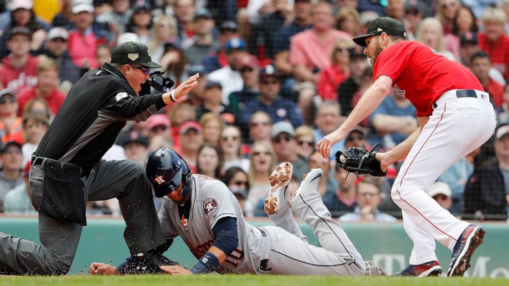 PHOTO: Houston Astros' Yuli Gurriel, center, is called safe by umpire Cory Blaser, left, after scoring on a wild pitch by starting pitcher Chris Sale, right, during the second inning of a baseball game, May 19, 2019, at Fenway Park in Boston.