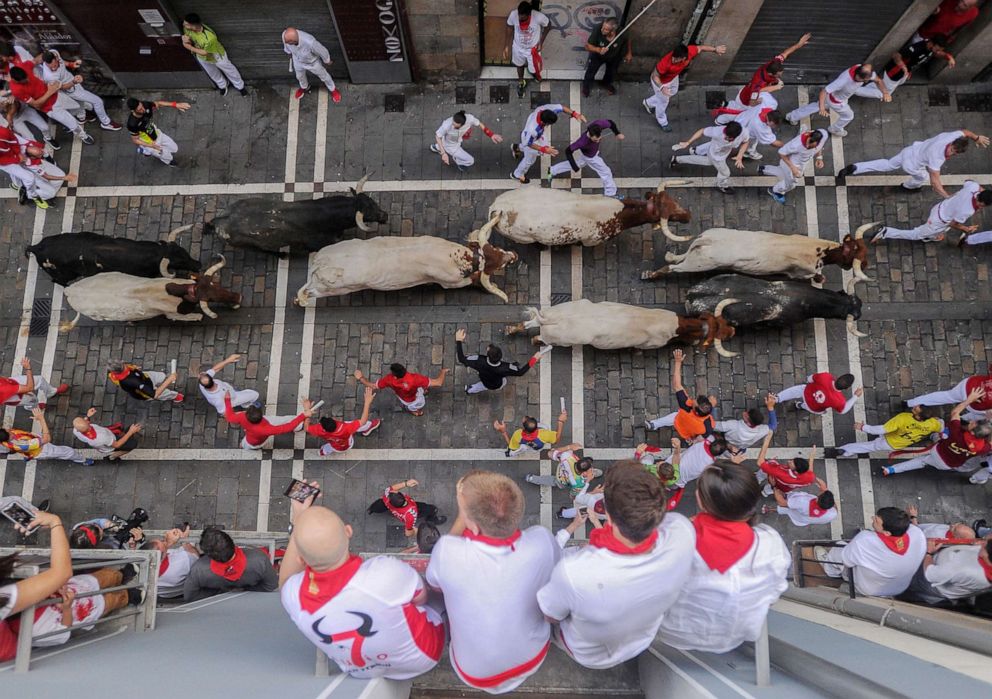 PHOTO: Revellers observe as participants run with Miura fighting bulls on the last bullrun of the San Fermin festival in Pamplona, Spain, July 12, 2019.