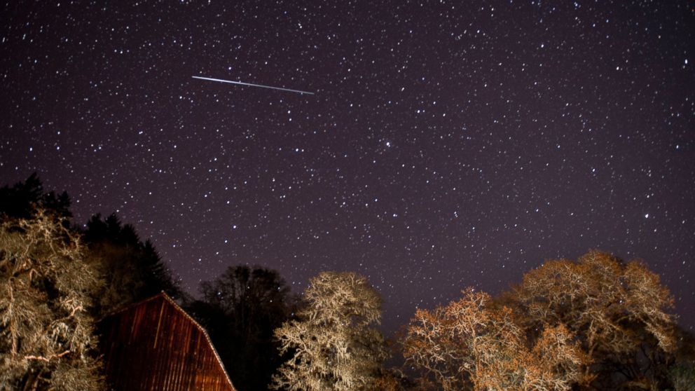 A meteor from the Lyrid meteor shower streaks through the sky above a barn along a country road near Oakland, Ore. on April 21, 2012.