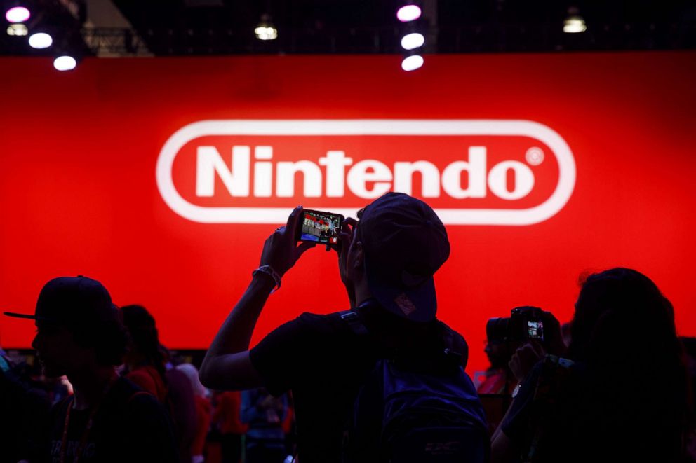 PHOTO: Attendees take photographs while waiting to enter the Nintendo Co. Pokemon Sword and Shield display during the E3 Electronic Entertainment Expo in Los Angeles, June 12, 2019.