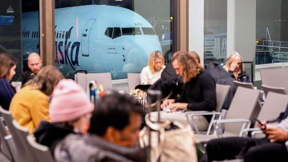 PHOTO: Travelers wait in the terminal as an Alaska Airlines plane sits at a gate at Los Angeles International Airport in Los Angeles, Jan. 11, 2023.