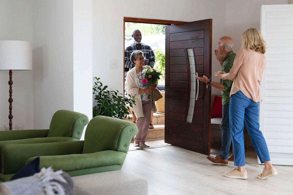 PHOTO: A visiting couple is greeted at the door by another couple in an undated stock image.