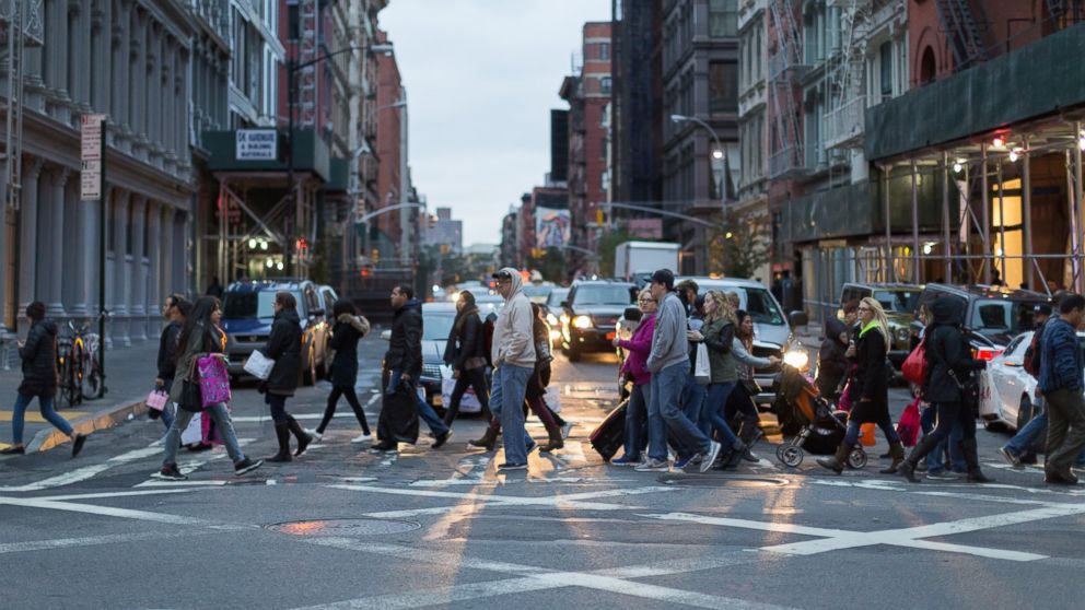 Cars stop at a crowded street crossing.