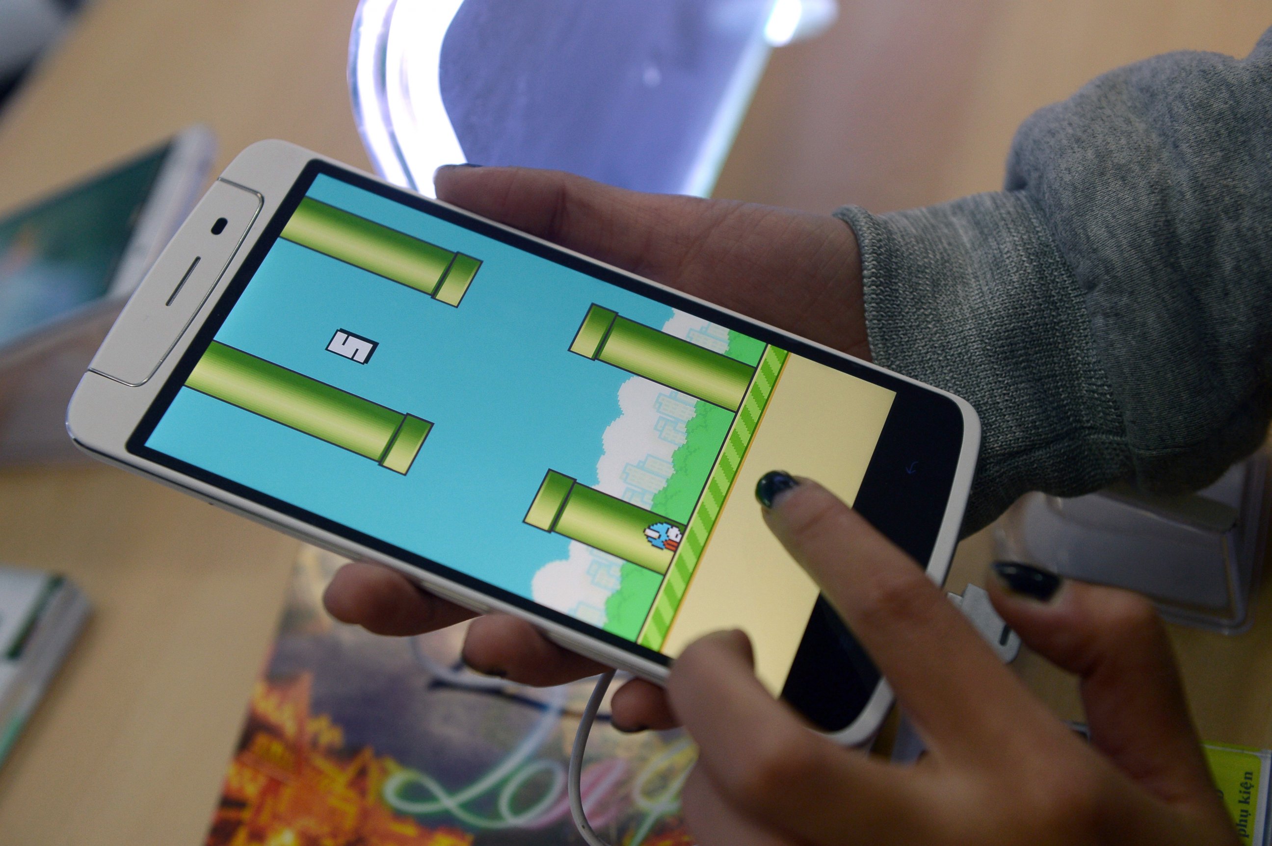 PHOTO: An employee plays the game Flappy Bird at a smartphone store in Hanoi on Feb. 10, 2014. 
