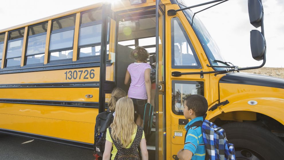 Children board a school bus in an undated stock photo.