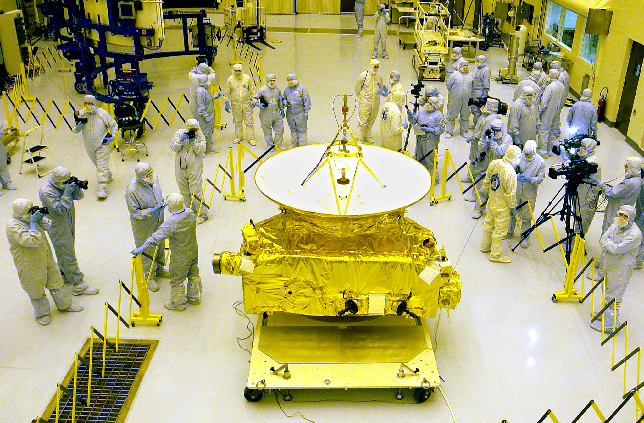 PHOTO: Members of the media garbed in protective uniforms view NASA's New Horizons spacecraft on Nov. 4, 2005 at Kennedy Space Center in Florida.