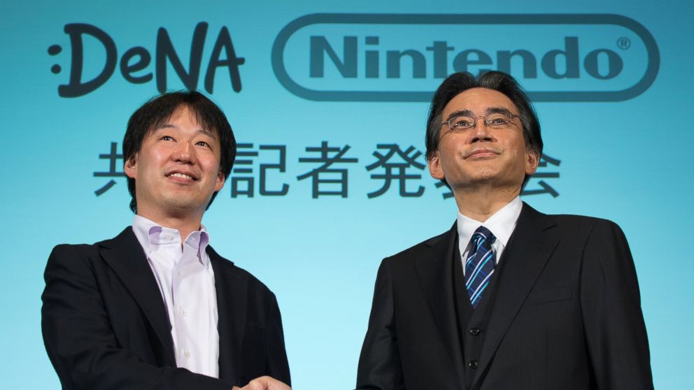 PHOTO: Satoru Iwata, president of Nintendo Co., right, and Isao Moriyasu, president and chief executive officer of DeNA Co., shake hands during a joint news conference in Tokyo, Japan, March 17, 2015.
