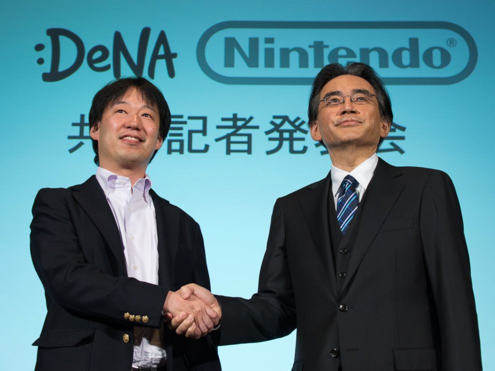 PHOTO: Satoru Iwata, president of Nintendo Co., right, and Isao Moriyasu, president and chief executive officer of DeNA Co., shake hands during a joint news conference in Tokyo, Japan, March 17, 2015.