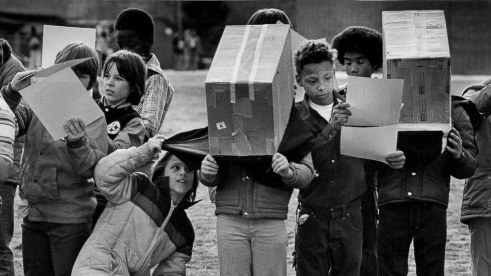 Denver public school students watch a partial solar eclipse using viewing boxes in 1979.