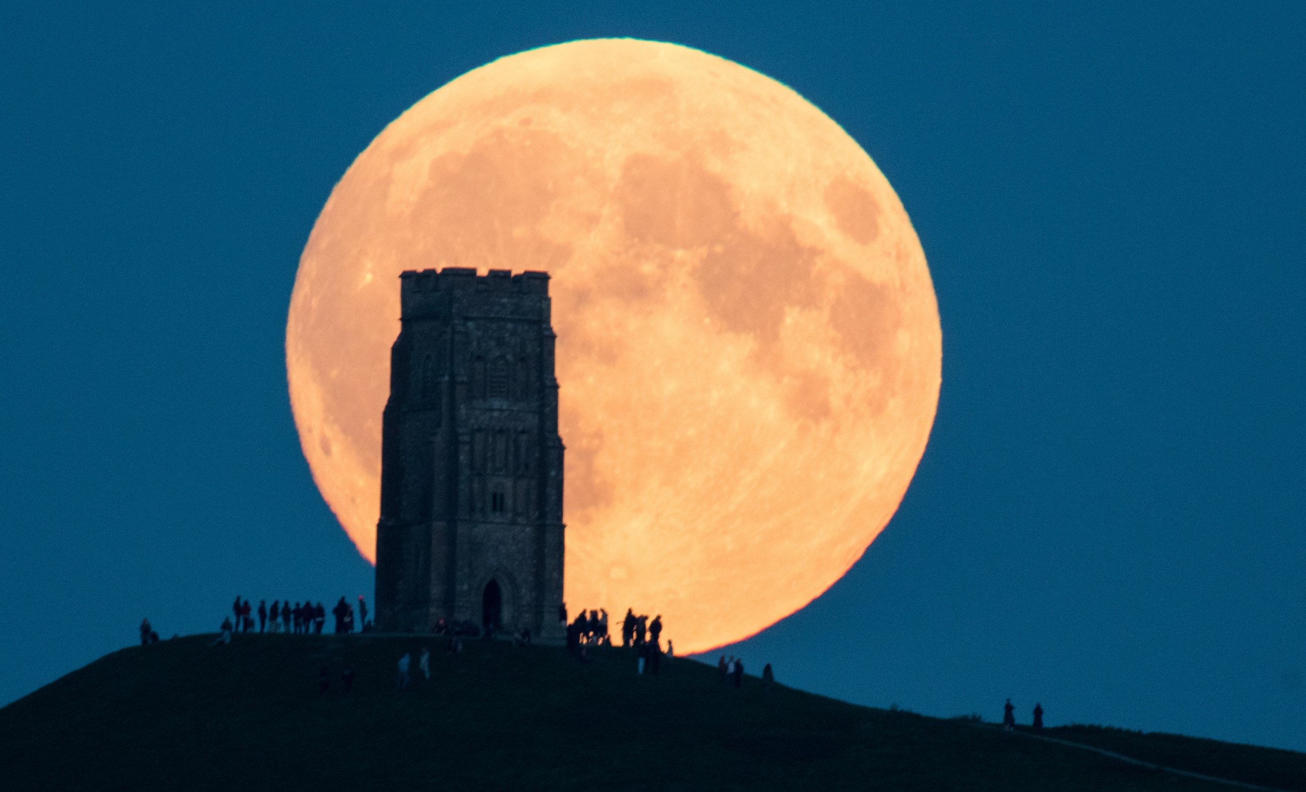 PHOTO: The supermoon rises behind Glastonbury Tor on September 28, 2015 in Somerset, England.