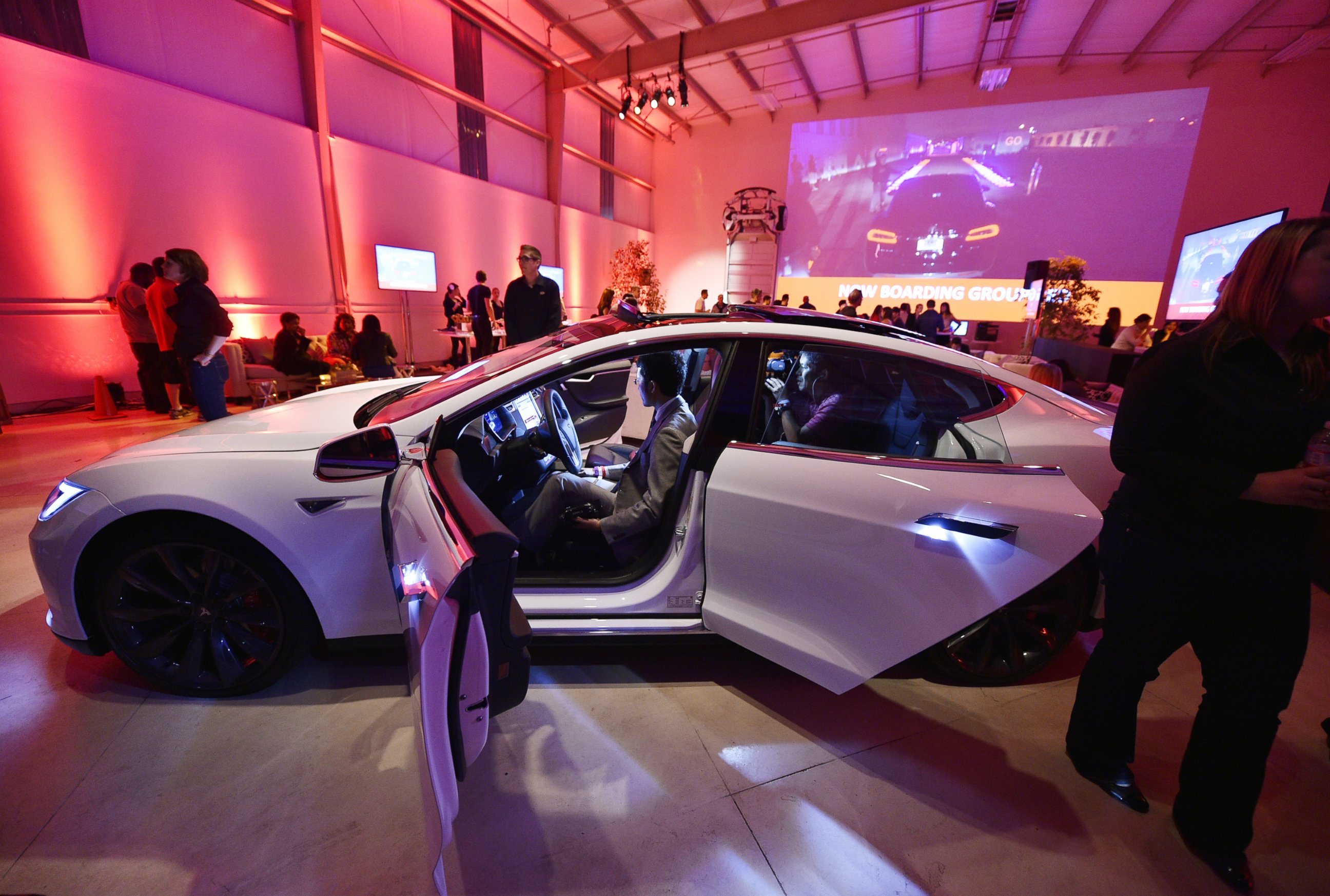 PHOTO: Tesla owners look at the new interior of a Tesla "D" model electric sedan at the Hawthorne Airport Oct. 09, 2014 in Hawthorne, Calif.