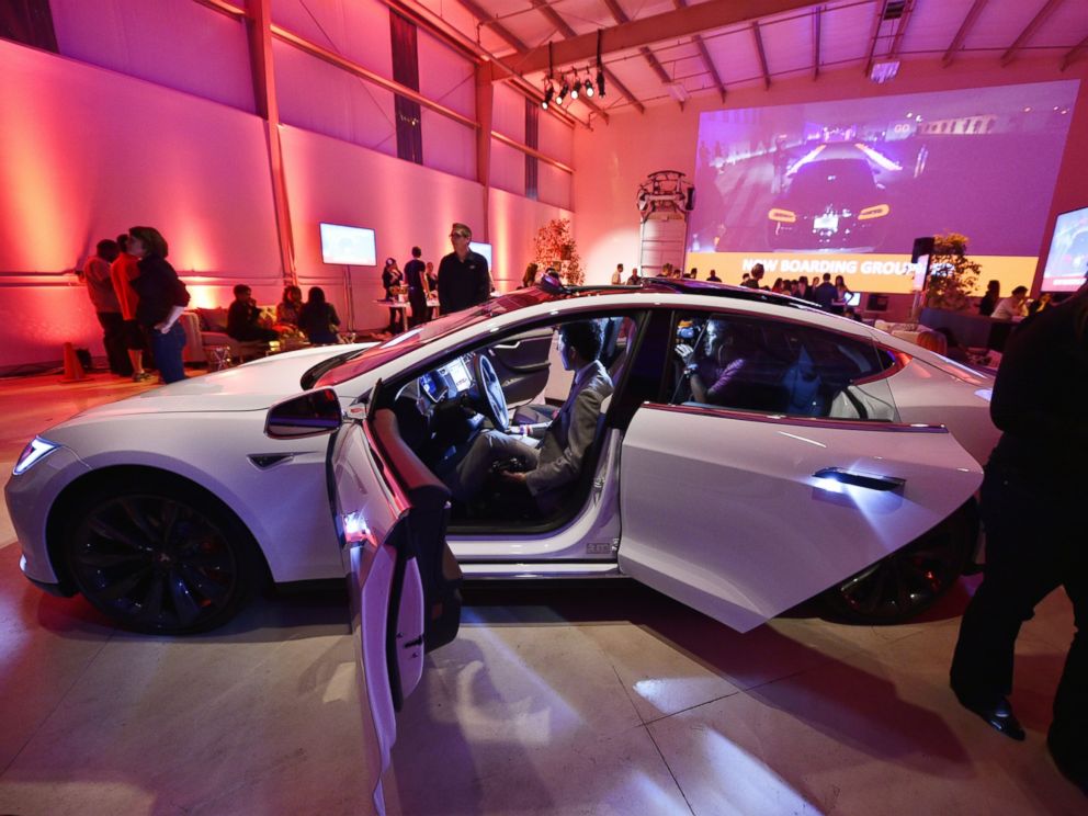 PHOTO: Tesla owners look at the new interior of a Tesla D model electric sedan at the Hawthorne Airport Oct. 09, 2014 in Hawthorne, Calif.