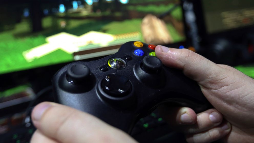 A visitor holds a hand control unit as he plays "Minecraft" on a Microsoft Xbox One console during an event at Earls Court in London, Sept. 25, 2014.