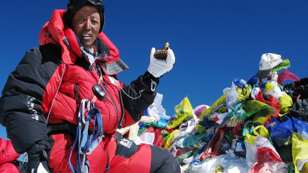 Apa Sherpa poses on the summit of Mount Everest with a memorial to mountaineer Sir Edmund Hillary in an undated handout image.