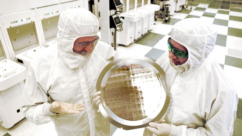 SUNY College of Nanoscale Science and Engineering's Michael Liehr, left, and IBM's Bala Haranand look at wafer comprised of 7nm chips on Thursday, July 2, 2015, in a NFX clean room Albany.  