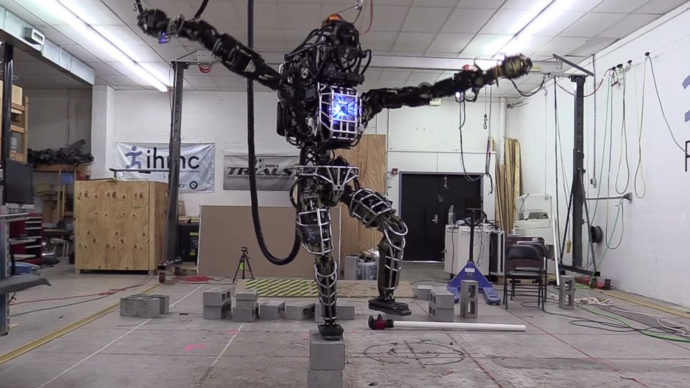 A robot developed by Boston Dynamics stands on a pile of cinder blocks and mimics a pose from the movie "Karate Kid" in a video uploaded to YouTube on Nov. 8, 2014 titled, "20141108 115244 Atlas KarateKid."