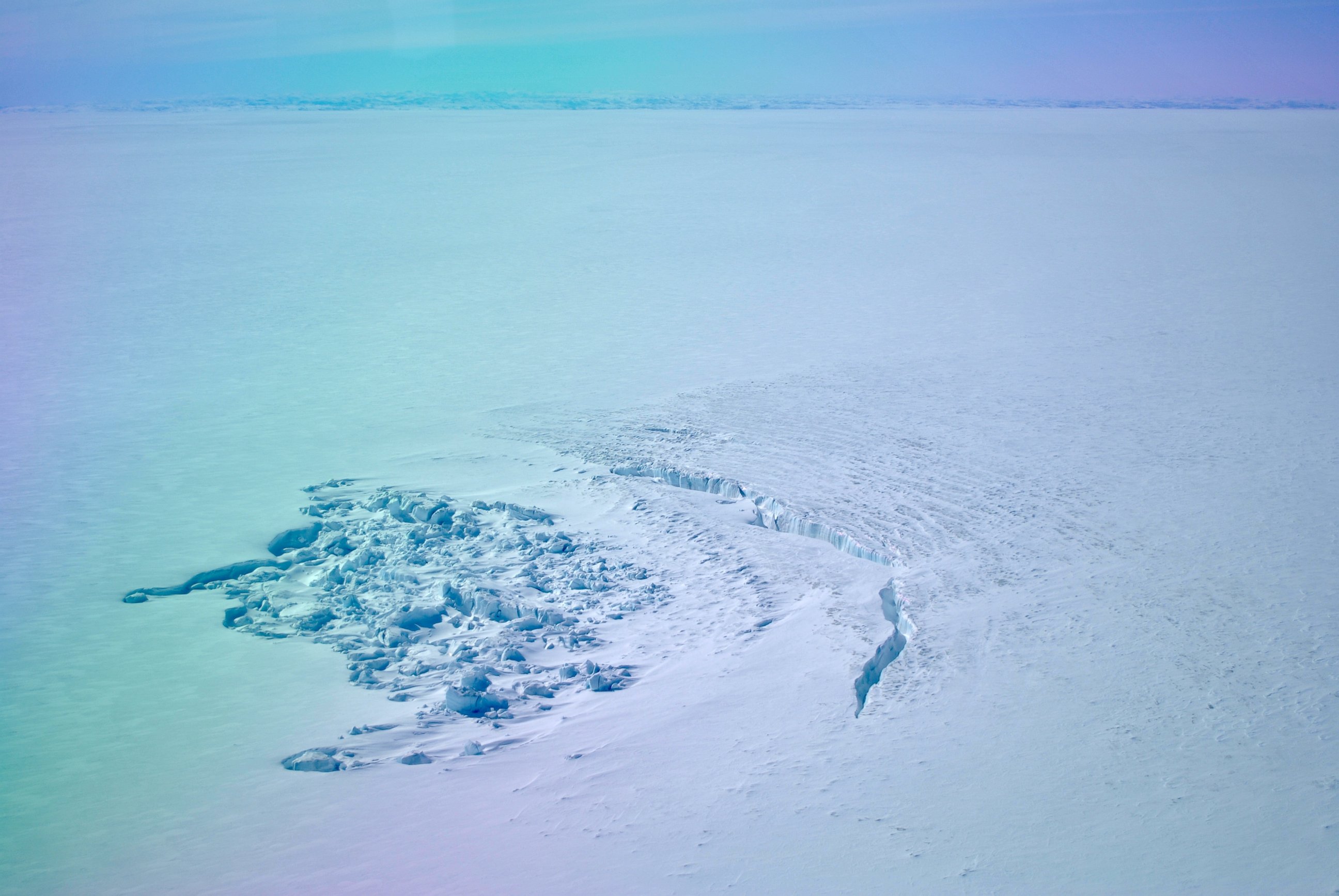 PHOTO: In April 2014, researchers flew over a site in southwest Greenland to find that a sub-glacial lake had drained away. This photo shows the crater left behind, as well as a deep crack in the ice. 