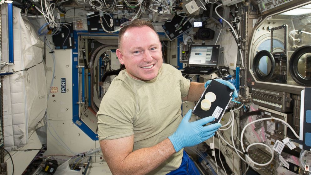 NASA astronaut Butch Wilmore holds a container, the first object with two parts, a lid and container, printed in space.