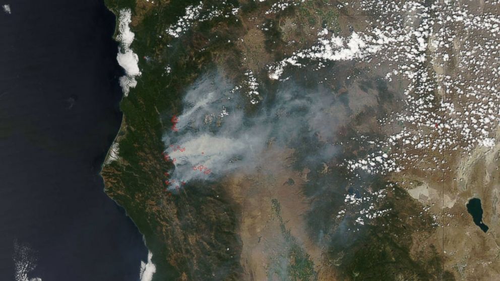 The smoke still rising from California is seen in this satellite image. The actively burning areas, detected by MODIS’s thermal bands, are outlined in red and the smoke is grey. 