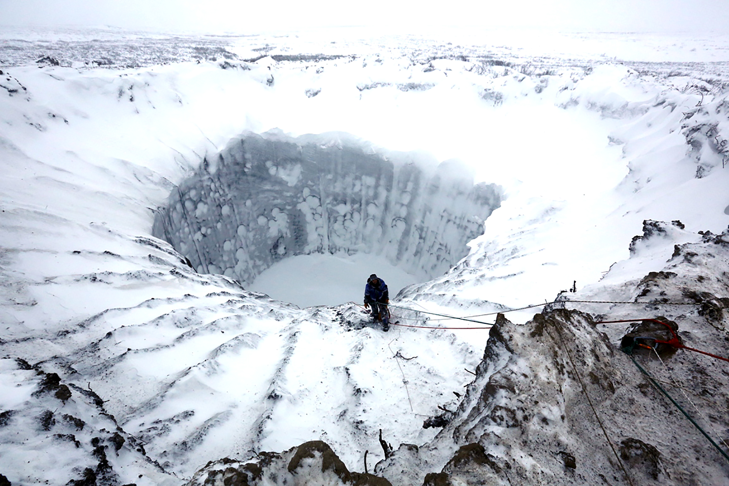 PHOTO: A scientist looks to the bottom of a crater on the Yamal peninsula in Siberia, Nov. 9, 2014.