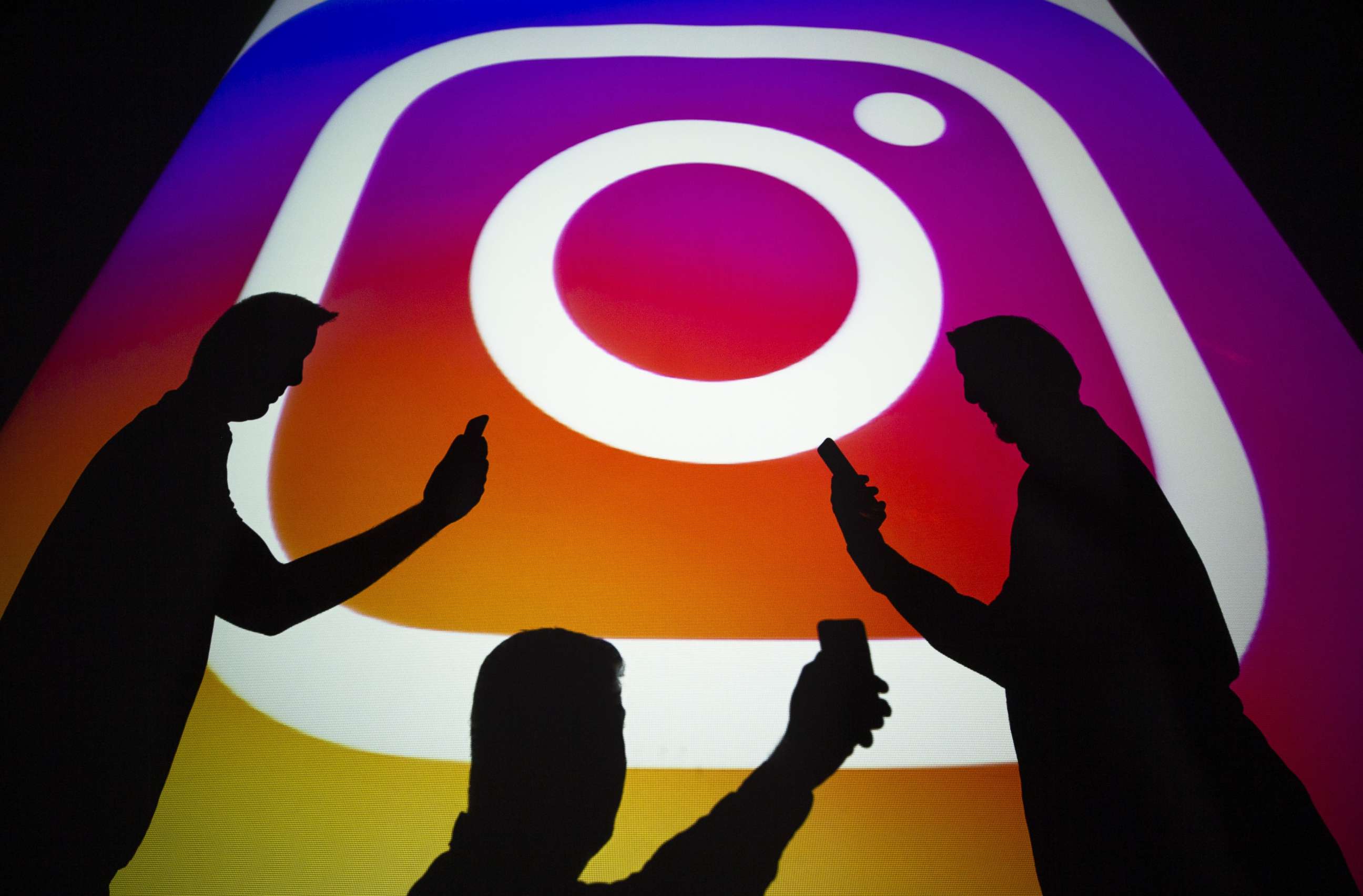 PHOTO: A photo shows silhouettes of men in front of the logo of 'Instagram' social media platform in Ankara, Turkey on September 25, 2018.