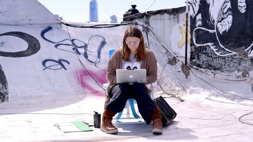 PHOTO: A school teacher teaches on her laptop from her roof in New York, March 24, 2020.
