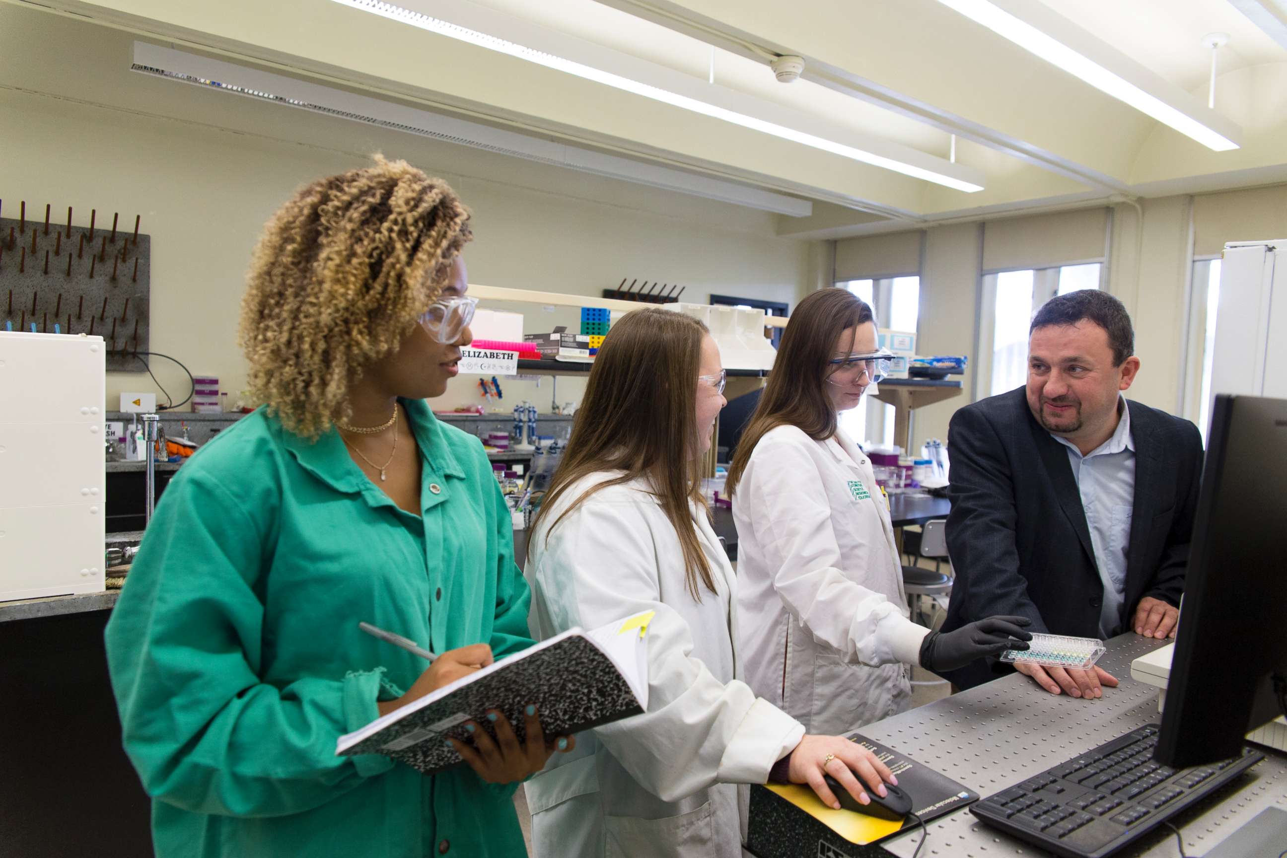 PHOTO: Assistant Professor Jan Halamek, Ph.D, working with Erica Brunelle, 4th year Chemistry PhD candidate; Mindy Hair, 2nd year Chemistry PhD candidate; and Adrianna Mathis '18 Chemistry, Nov. 2, 2017.