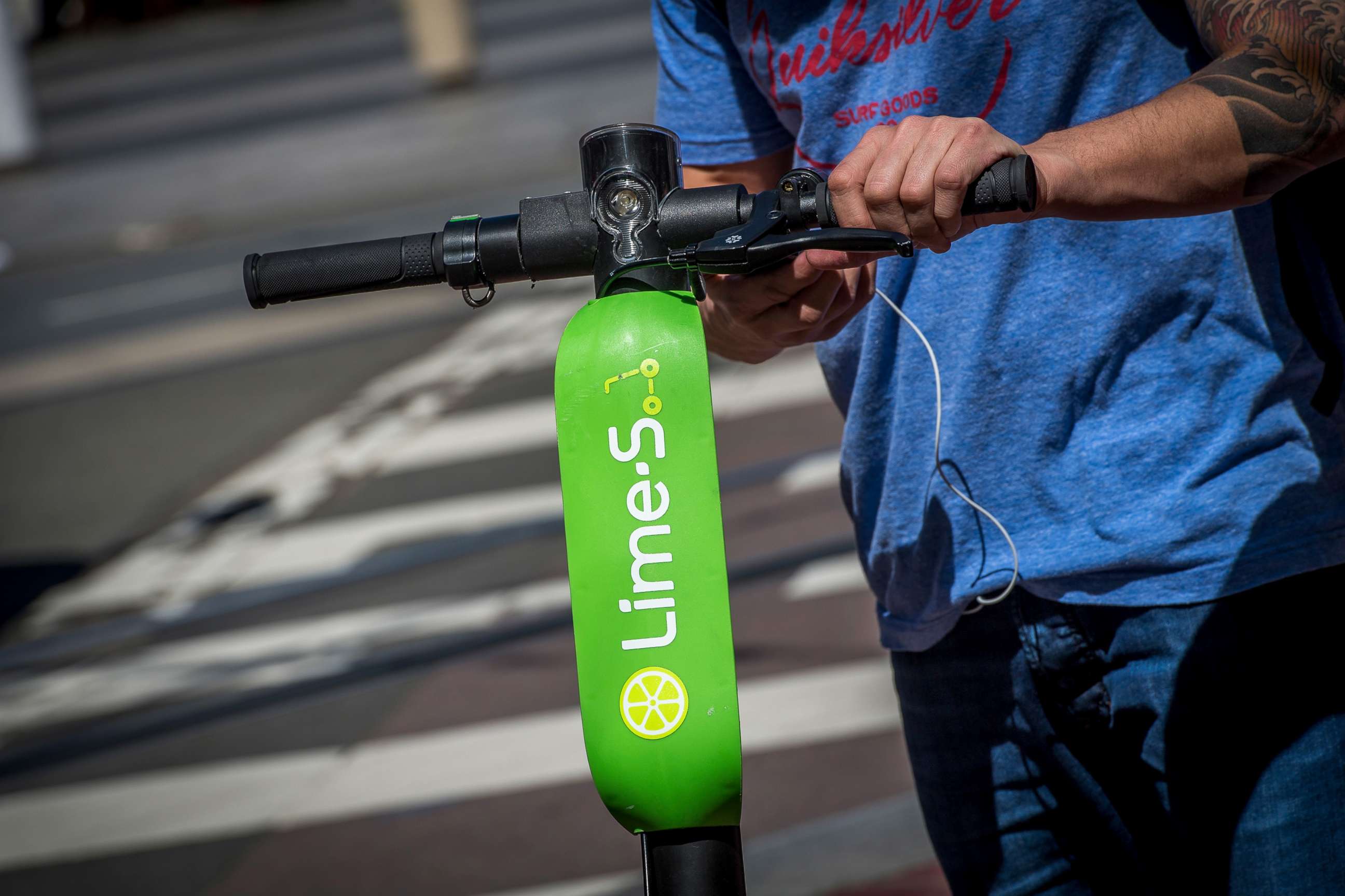 PHOTO: A person unlocks a Neutron Holdings Inc. LimeBike shared electric scooter on Market Street in San Francisco, April 13, 2018.