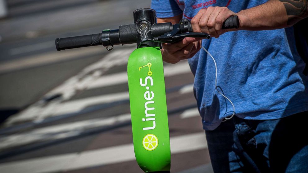 PHOTO: A person unlocks a Neutron Holdings Inc. LimeBike shared electric scooter on Market Street in San Francisco, April 13, 2018.