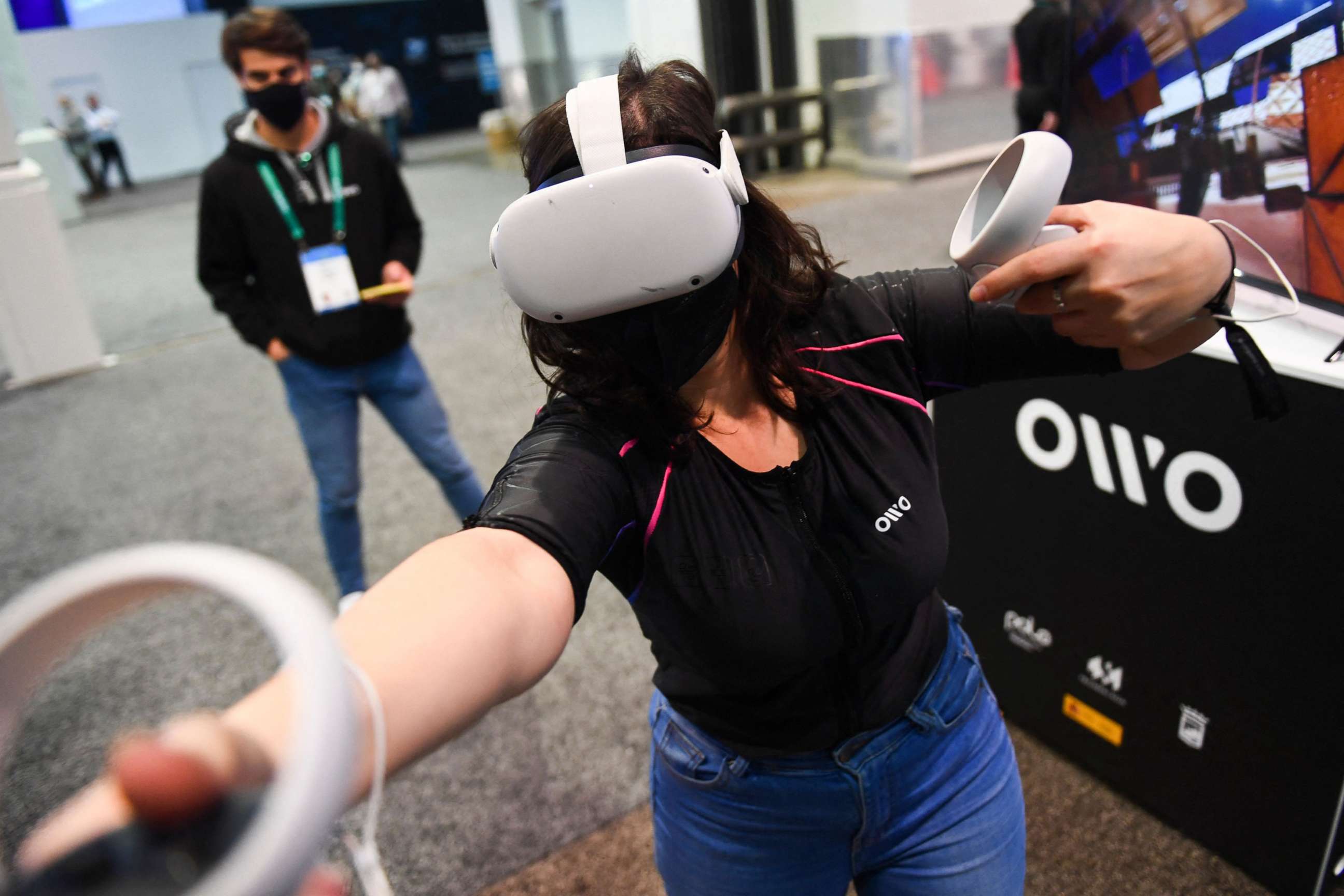 PHOTO: An attendee demonstrates the Owo vest, which allows users to feel physical sensations during metaverse experiences such as virtual reality games, including wind, gunfire or punching, at the Consumer Electronics Show on Jan. 5, 2022, in Las Vegas.