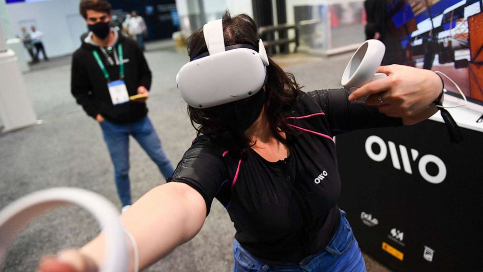 PHOTO: An attendee demonstrates the Owo vest, which allows users to feel physical sensations during metaverse experiences such as virtual reality games, including wind, gunfire or punching, at the Consumer Electronics Show on Jan. 5, 2022, in Las Vegas.