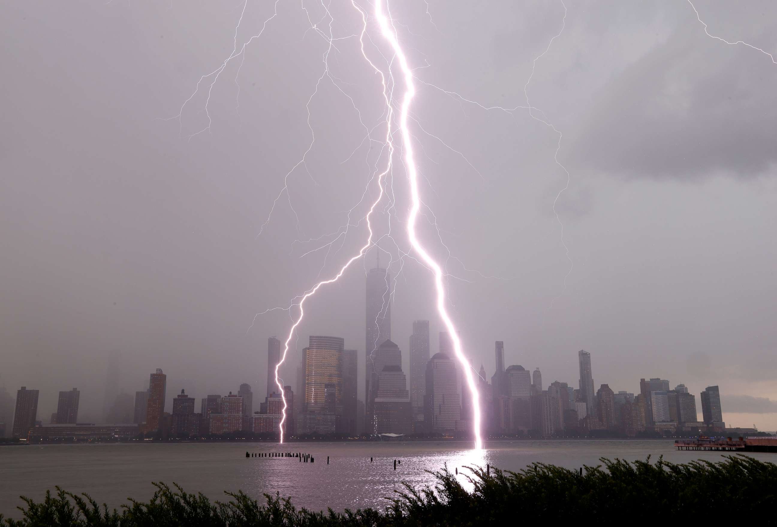 PHOTO: In this July 6, 2020, file photo, two lightning bolts frame One World Trade Center as they hit the Hudson River in New York during a thunderstorm.